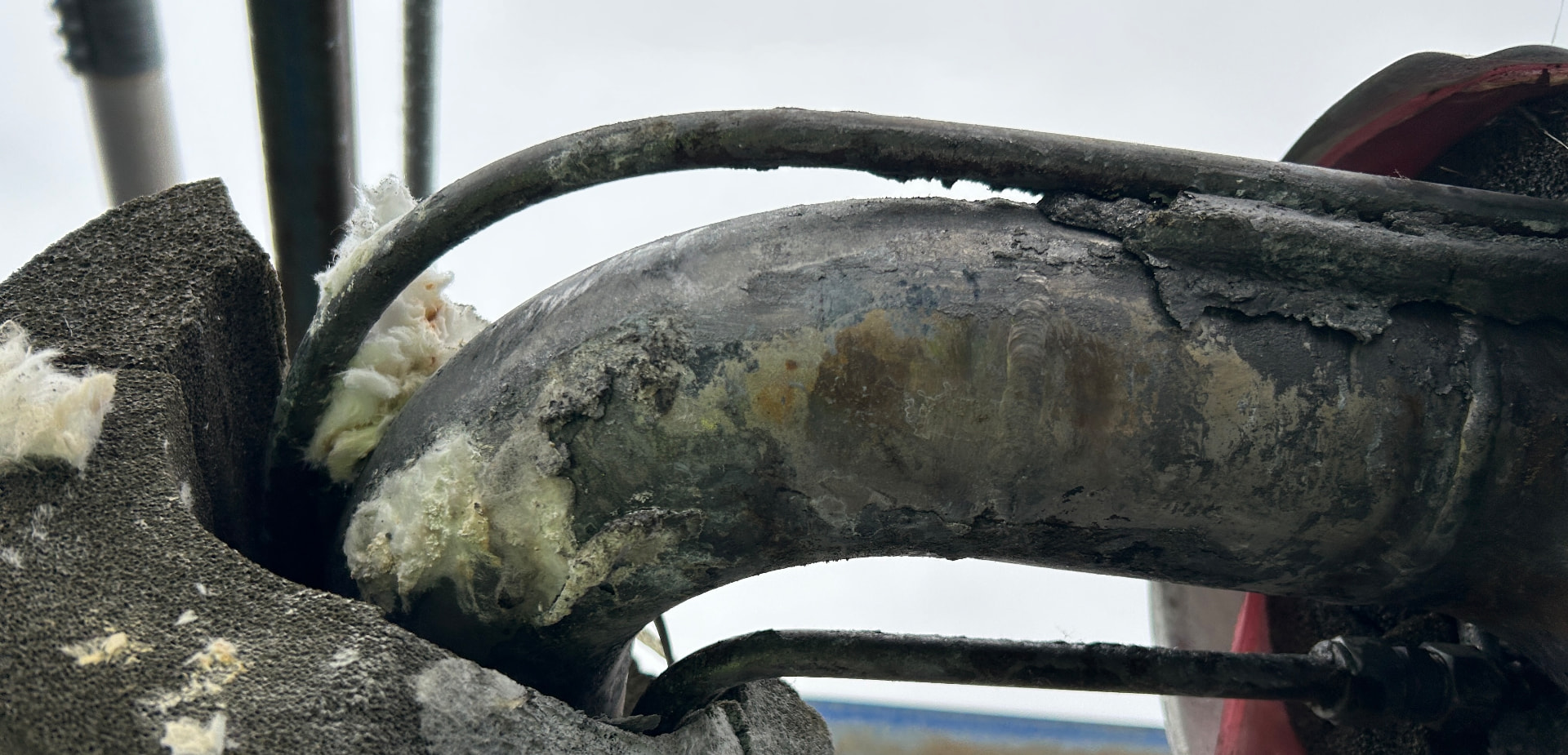 Insulated process pipe with exposed steam tracer showing poor contact and cold elbow