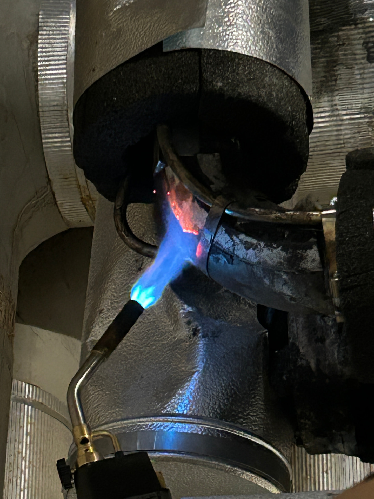 Blowtorch heating an industrial pipe with steam tracing